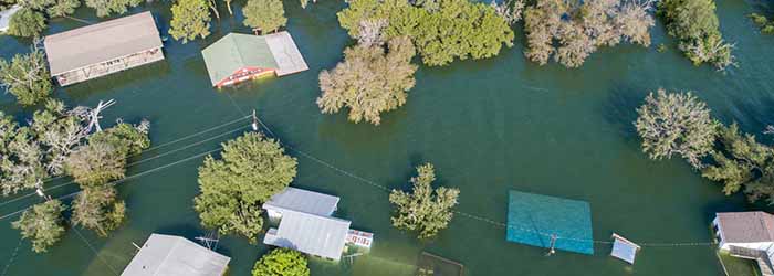 Aerial view of houses and trees partially submerged by floodwater - keatsagency.com