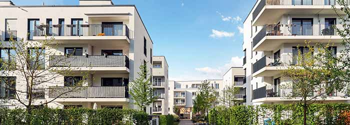 Modern multi‑family apartment complex with recessed balconies - keatsagency.com